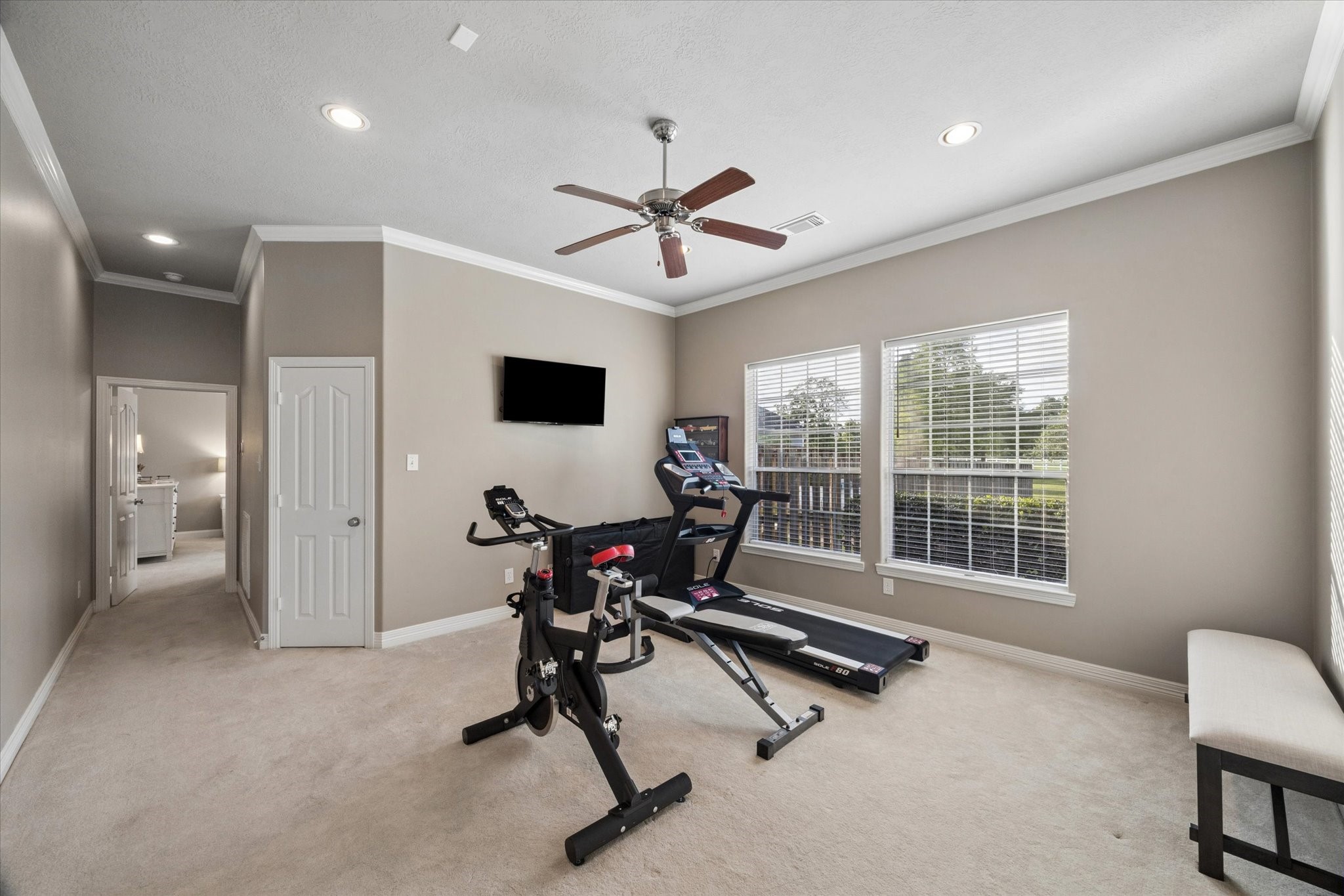 16519 Deerhaven Run Rosharon, TX 77583 - Photo 22 of 47 a view of a room with gym equipment and a large window