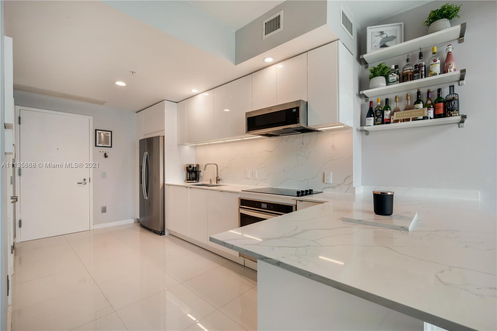 60 Southwest 13th Street, Unit 2204 Miami, FL 33130 - Photo 2 of 25 a kitchen with stainless steel appliances granite countertop a sink and a refrigerator