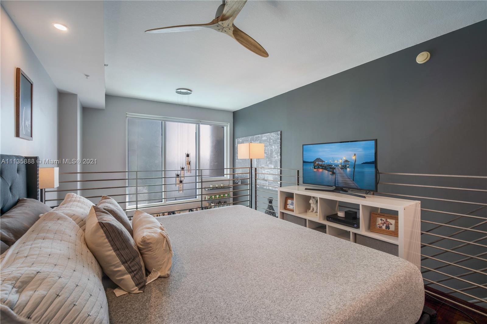 60 Southwest 13th Street, Unit 2204 Miami, FL 33130 - Photo 16 of 25 a bedroom with a bed and a chandelier