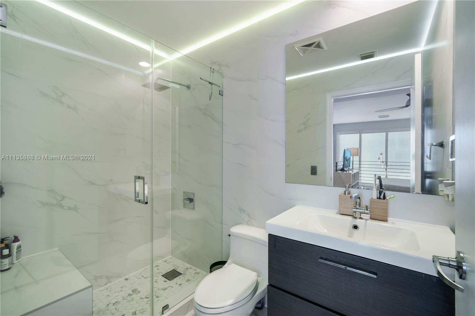 60 Southwest 13th Street, Unit 2204 Miami, FL 33130 - Photo 18 of 25 a bathroom with a sink toilet a mirror and shower