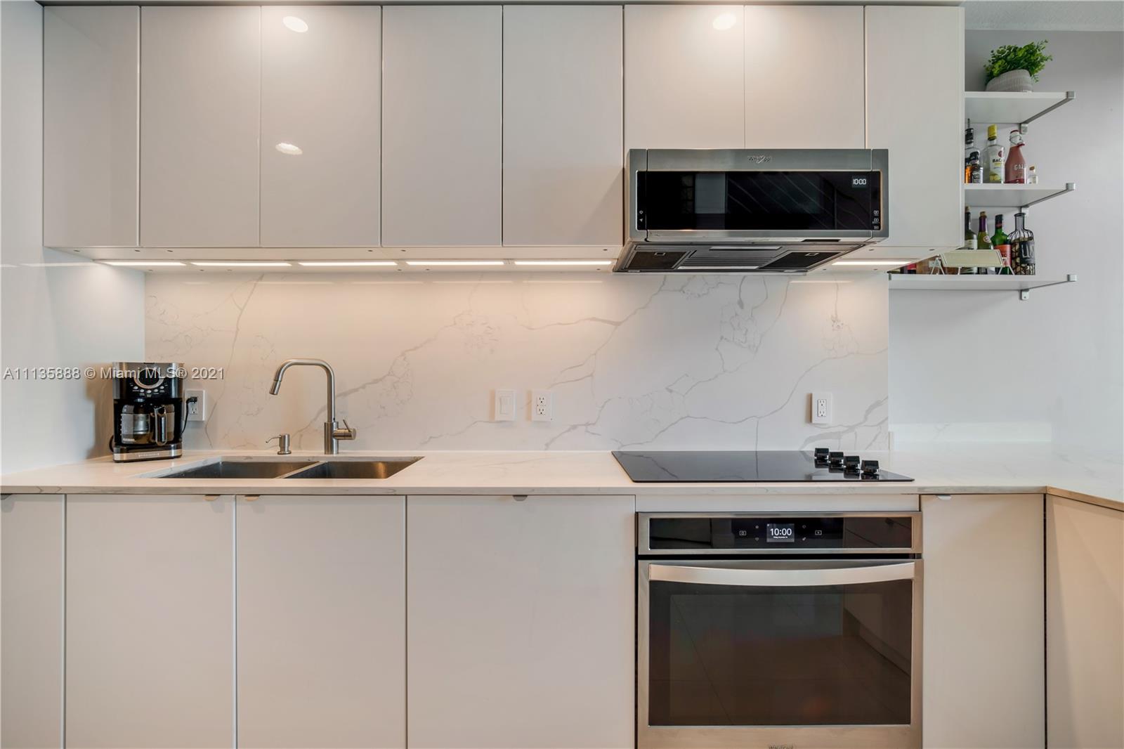 60 Southwest 13th Street, Unit 2204 Miami, FL 33130 - Photo 5 of 25 a kitchen with appliances a sink and cabinets