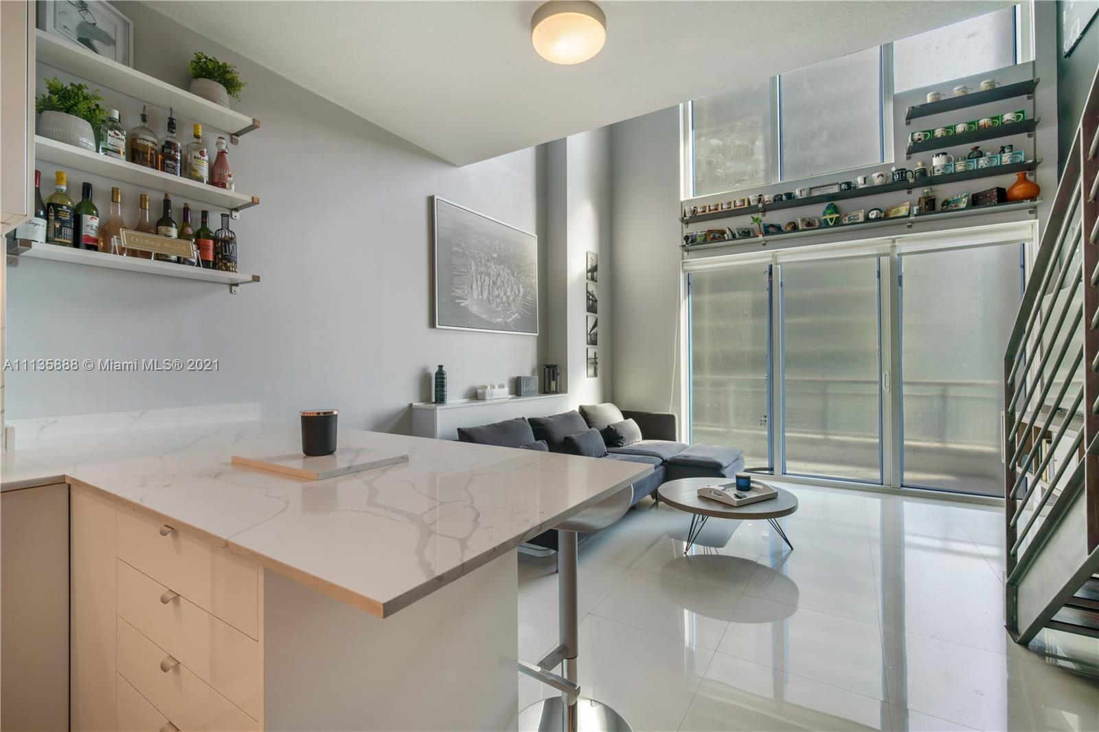 60 Southwest 13th Street, Unit 2204 Miami, FL 33130 - Photo 6 of 25 a view of a kitchen area with furniture and floor to ceiling window