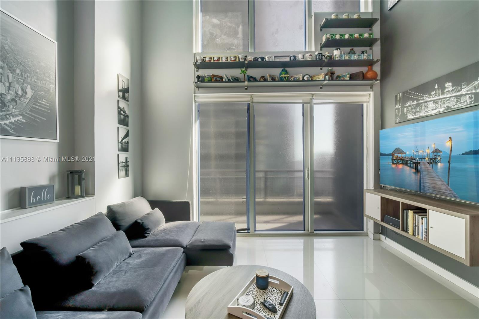 60 Southwest 13th Street, Unit 2204 Miami, FL 33130 - Photo 8 of 25 a living room with furniture and a floor to ceiling window