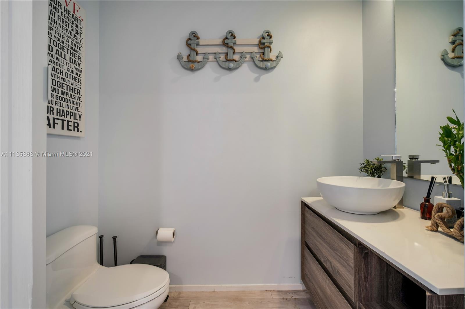 60 Southwest 13th Street, Unit 2204 Miami, FL 33130 - Photo 10 of 25 a bathroom with a toilet a sink and mirror