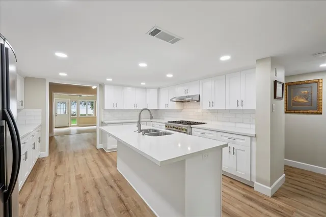 a large kitchen with stainless steel appliances a lot of counter space and a refrigerator