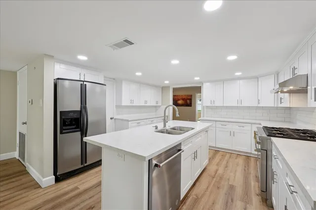 a kitchen with a sink stove cabinets and refrigerator