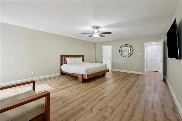 a spacious bedroom with a bed and a flat screen tv