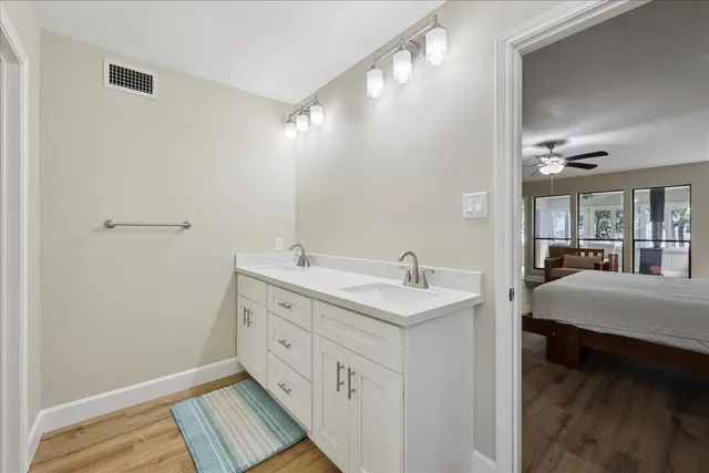 a spacious bathroom with a double vanity sink a mirror and a bathtub