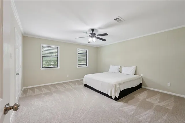 a spacious bedroom with a bed and a ceiling fan