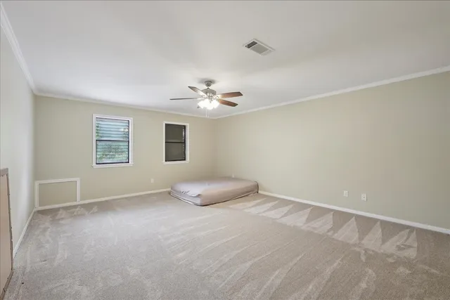 an empty room with a chandelier fan and window