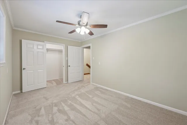 a view of an empty room and chandelier fan