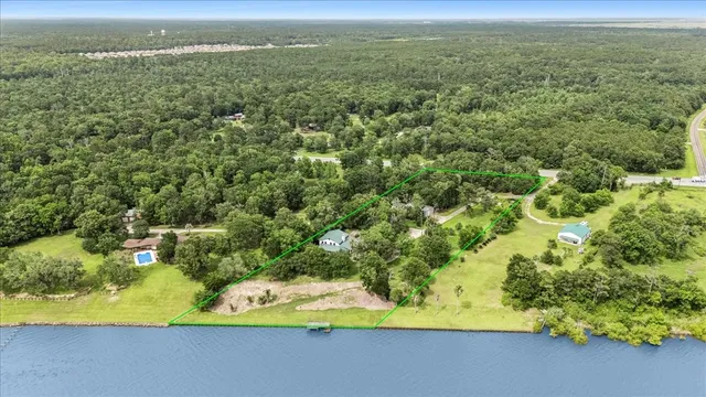 an aerial view of residential houses with outdoor space and trees