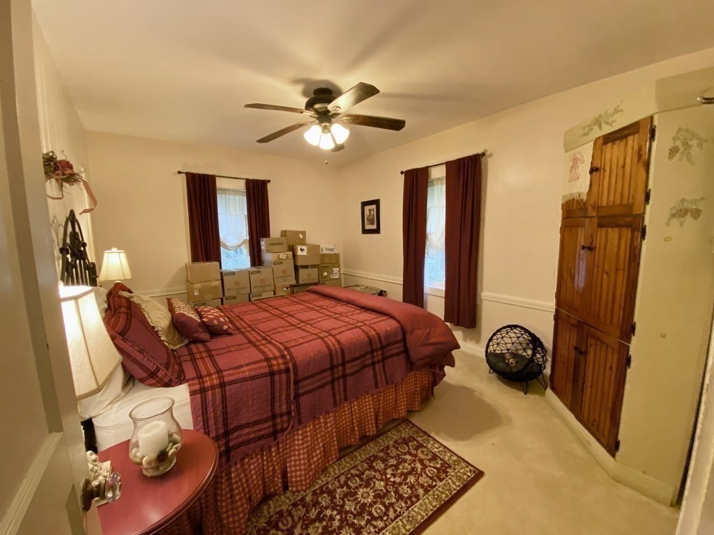 7 McGregory Road Sturbridge, MA 01566 - Photo 24 of 40 a bedroom with a bed and wooden floor