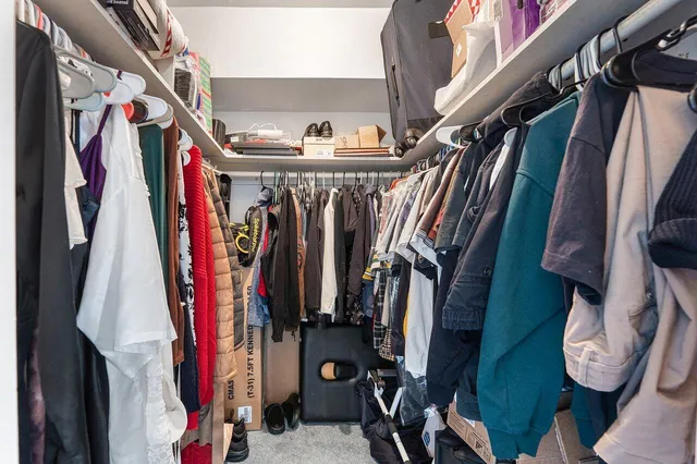 a view of walk in closet with clothes