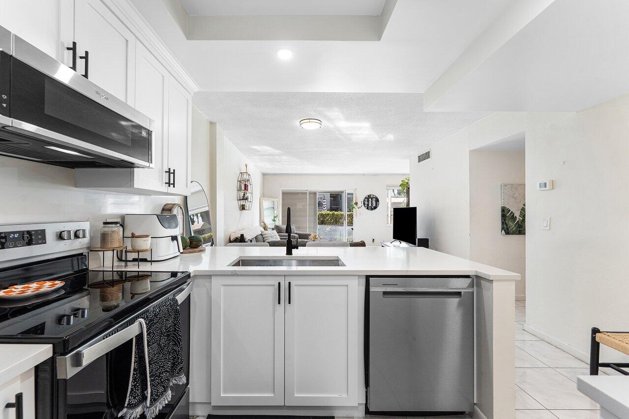 5701 Northwest 2nd Avenue Boca Raton, FL 33487 - Photo 7 of 26 a kitchen with a sink stove and cabinets
