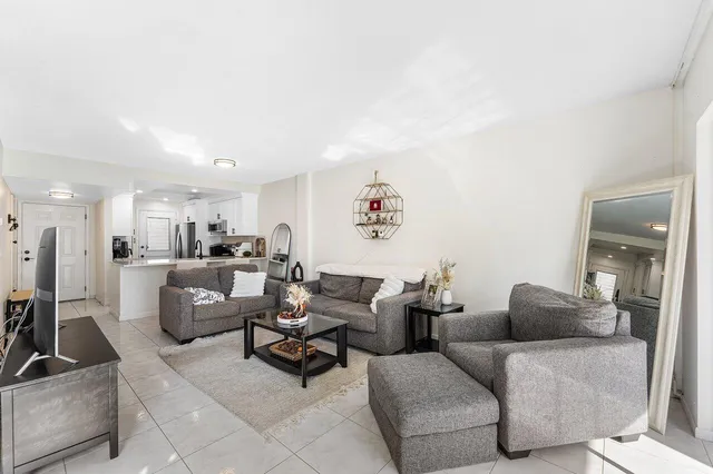 a living room with furniture and a view of kitchen