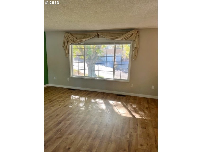 3331 Southwest Kirk Avenue Pendleton, OR 97801 - Photo 4 of 25 a view of an empty room with wooden floor and a window