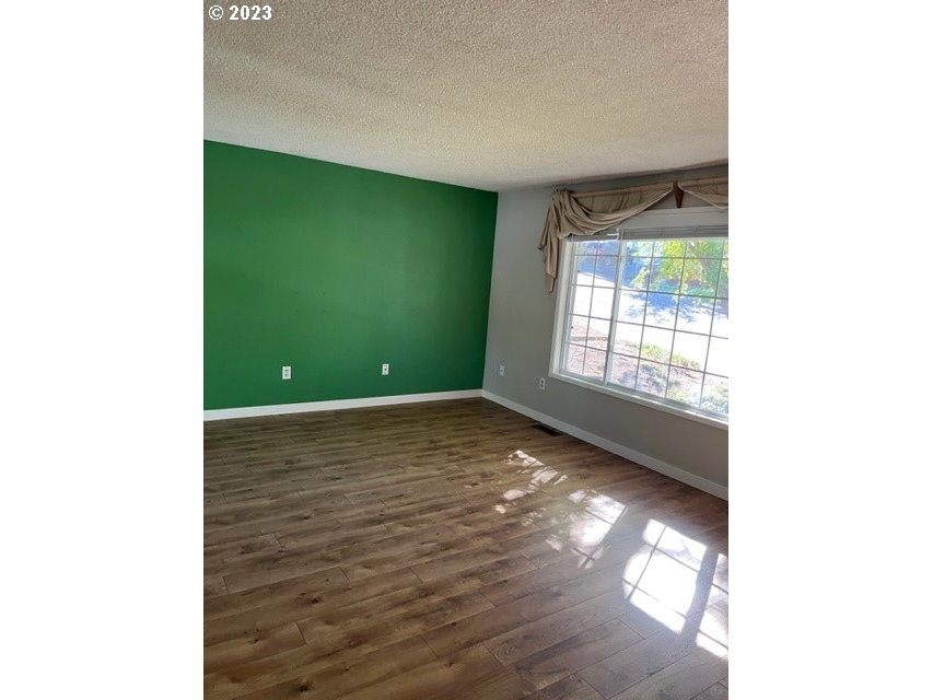 3331 Southwest Kirk Avenue Pendleton, OR 97801 - Photo 5 of 25 a view of an empty room with window and wooden floor