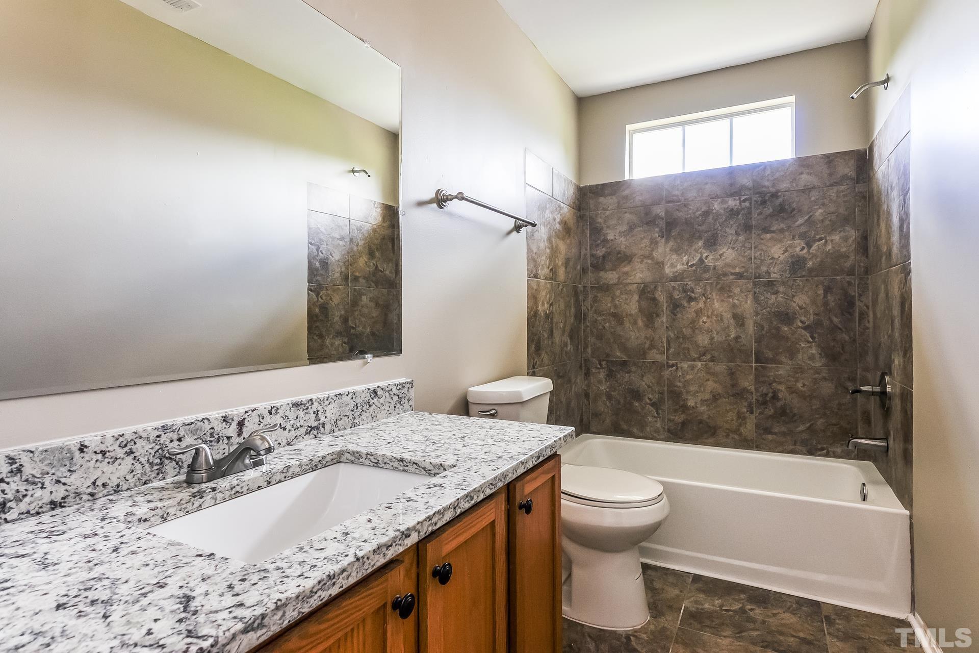313 Pebble Way Durham, NC 27703 - Photo 15 of 17 a bathroom with a granite countertop sink toilet and shower