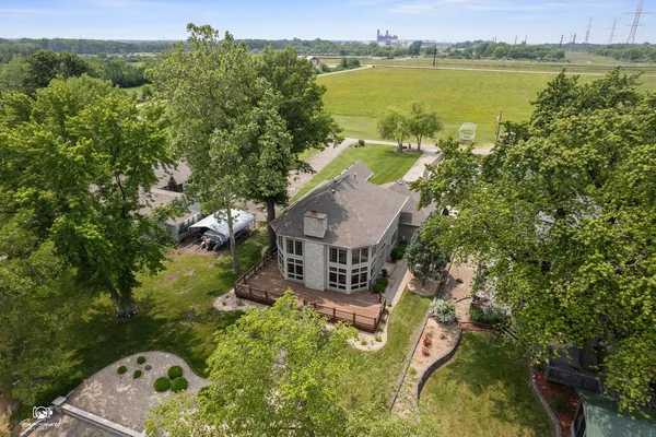 an aerial view of a house with a garden and lake view