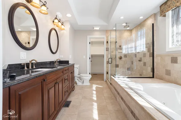 a spacious bathroom with a sink a mirror a bathtub and a shower