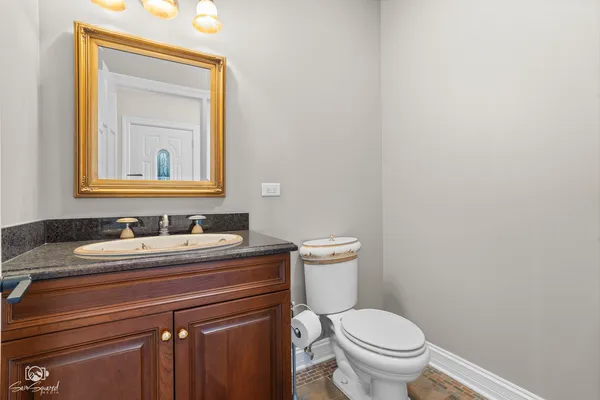a bathroom with a granite countertop toilet sink and mirror