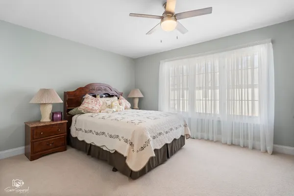 a spacious bedroom with a bed and a chandelier