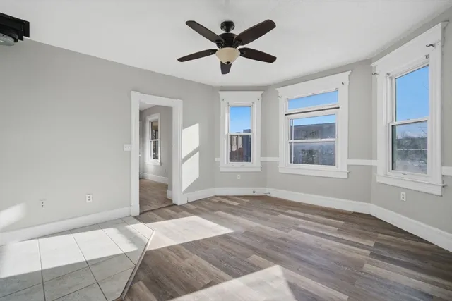a view of an empty room with window and a kitchen