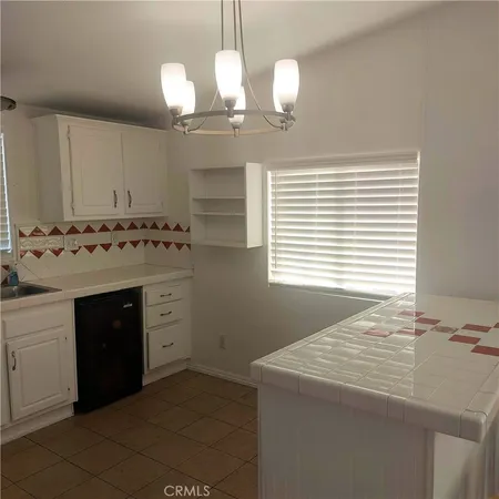 a kitchen with stainless steel appliances a sink a stove a refrigerator cabinets and a window