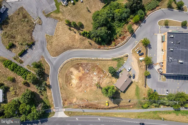 an aerial view of a residential houses with outdoor space and parking