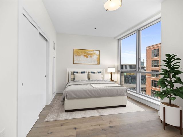 a bedroom with a large bed and a potted plant