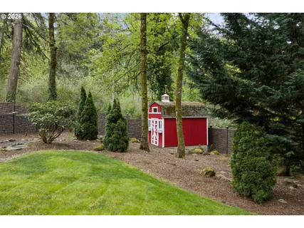 a view of a house with a yard and a large tree