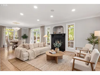 a living room with furniture potted plant a fireplace and a large window