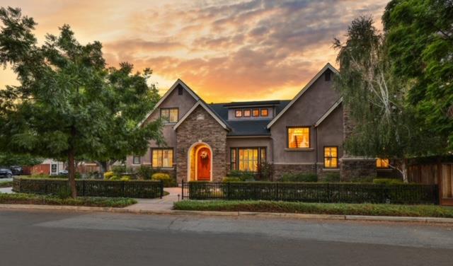 a view of a white house with a yard and plants next to a road