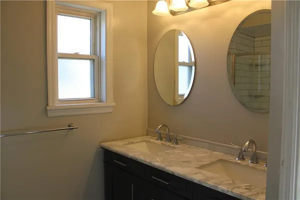 a bathroom with a granite countertop sink a mirror and a window