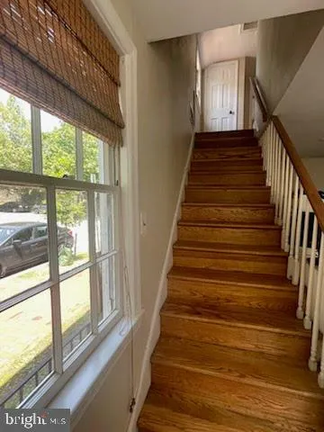 a view of staircase with wooden floor and windows