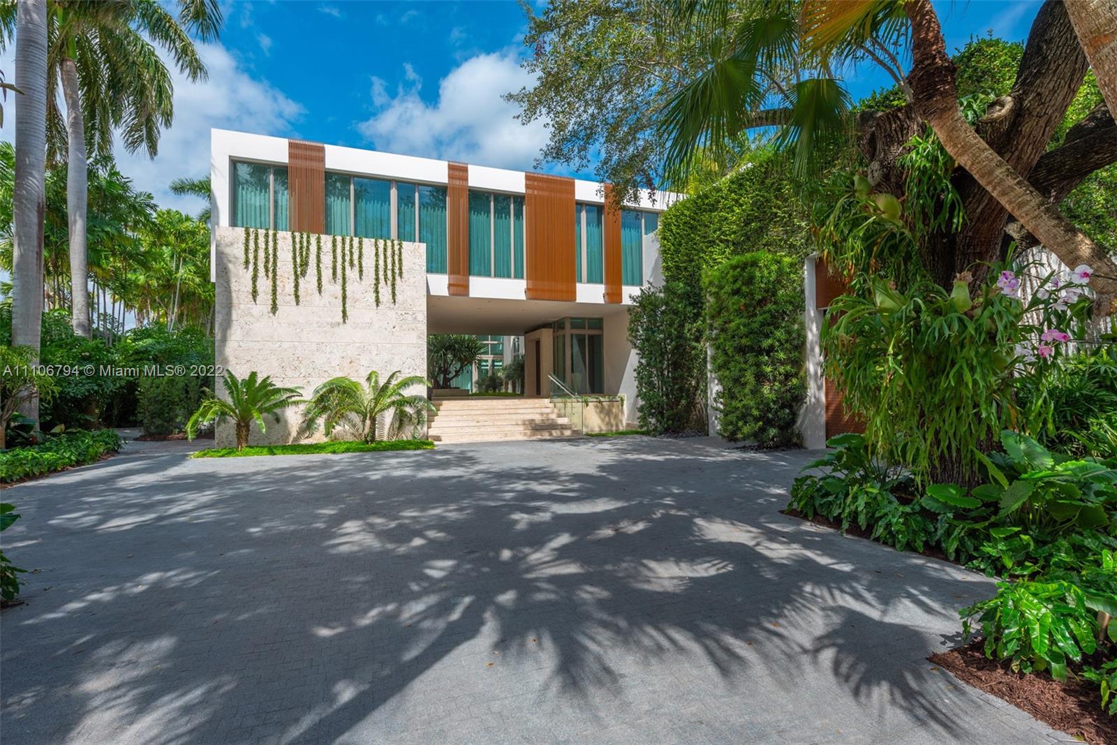 6396 North Bay Road Miami Beach, FL 33140 - Photo 4 of 12 a view of a brick house with plants and large trees