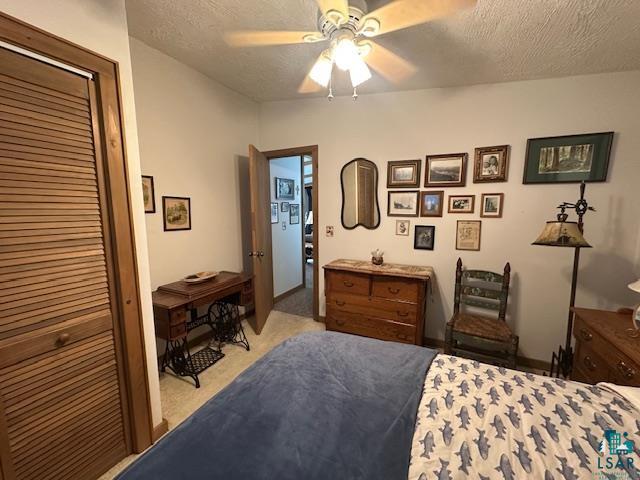 2734 Bear Island River Road Ely, MN 55731 - Photo 25 of 37 Bedroom featuring a textured ceiling, a closet, light carpet, and ceiling fan