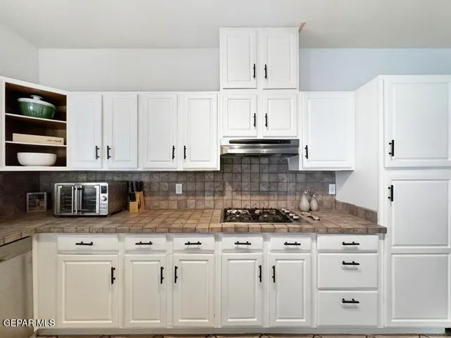 a kitchen with stainless steel appliances granite countertop a sink and a refrigerator