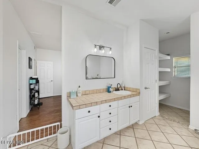 a bedroom with a bed couches and flat screen tv