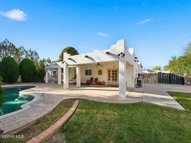 a white house that has tree in front of it