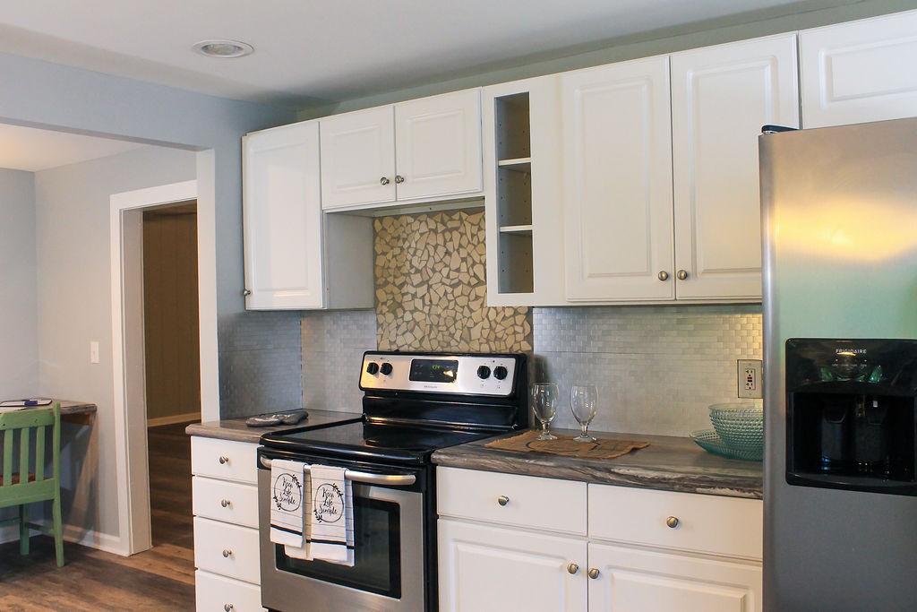 288 Clubbs Road Portland, TN 37148 - Photo 11 of 48 a kitchen with granite countertop a stove a sink and a white cabinets