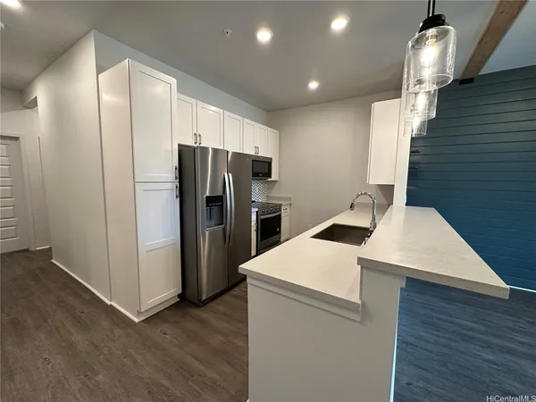 a kitchen that has a microwave a sink and a refrigerator