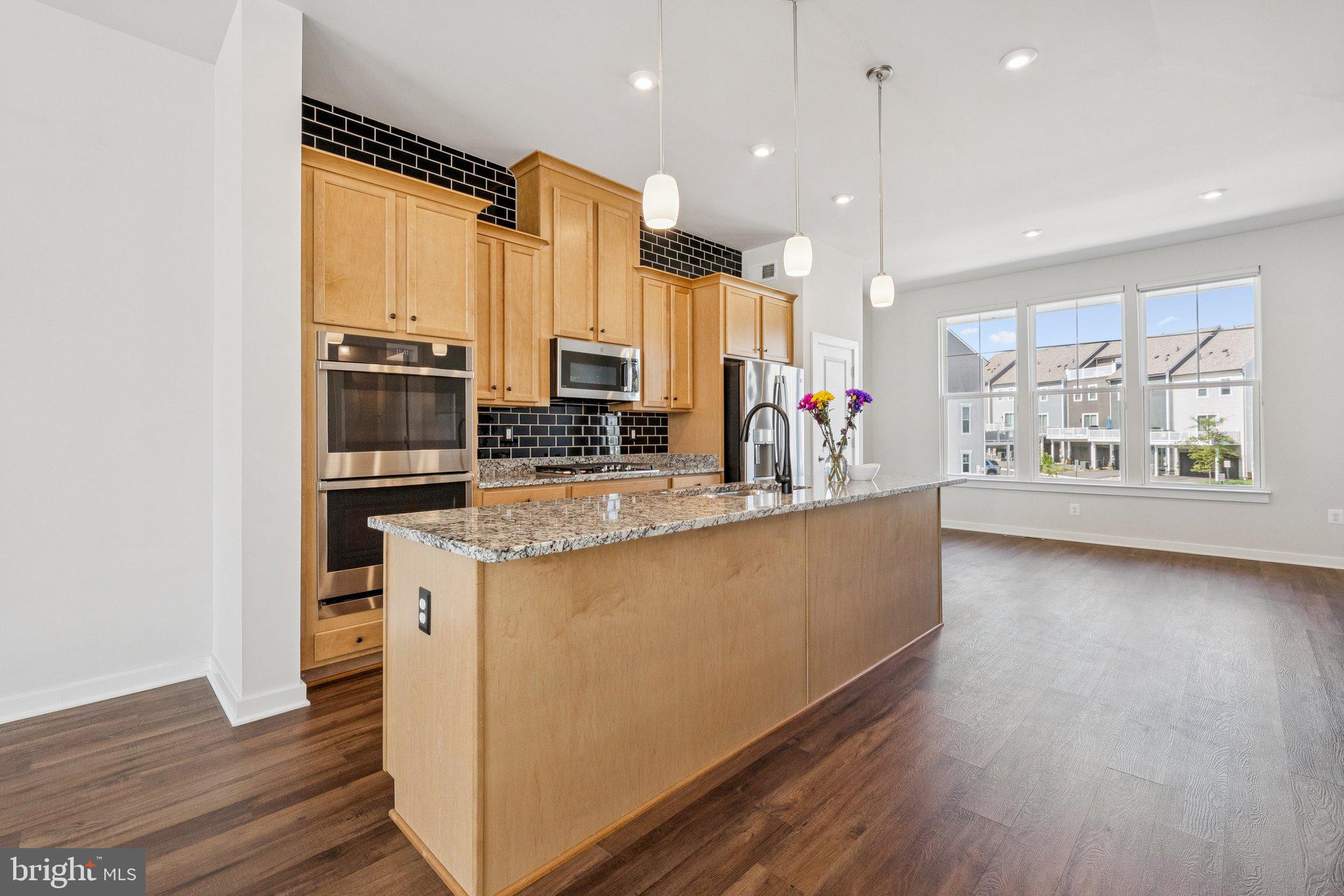 1655 Aspen Poplar Road Dumfries, VA 22026 - Photo 12 of 57 a large kitchen with stainless steel appliances a large counter top and a wooden floors