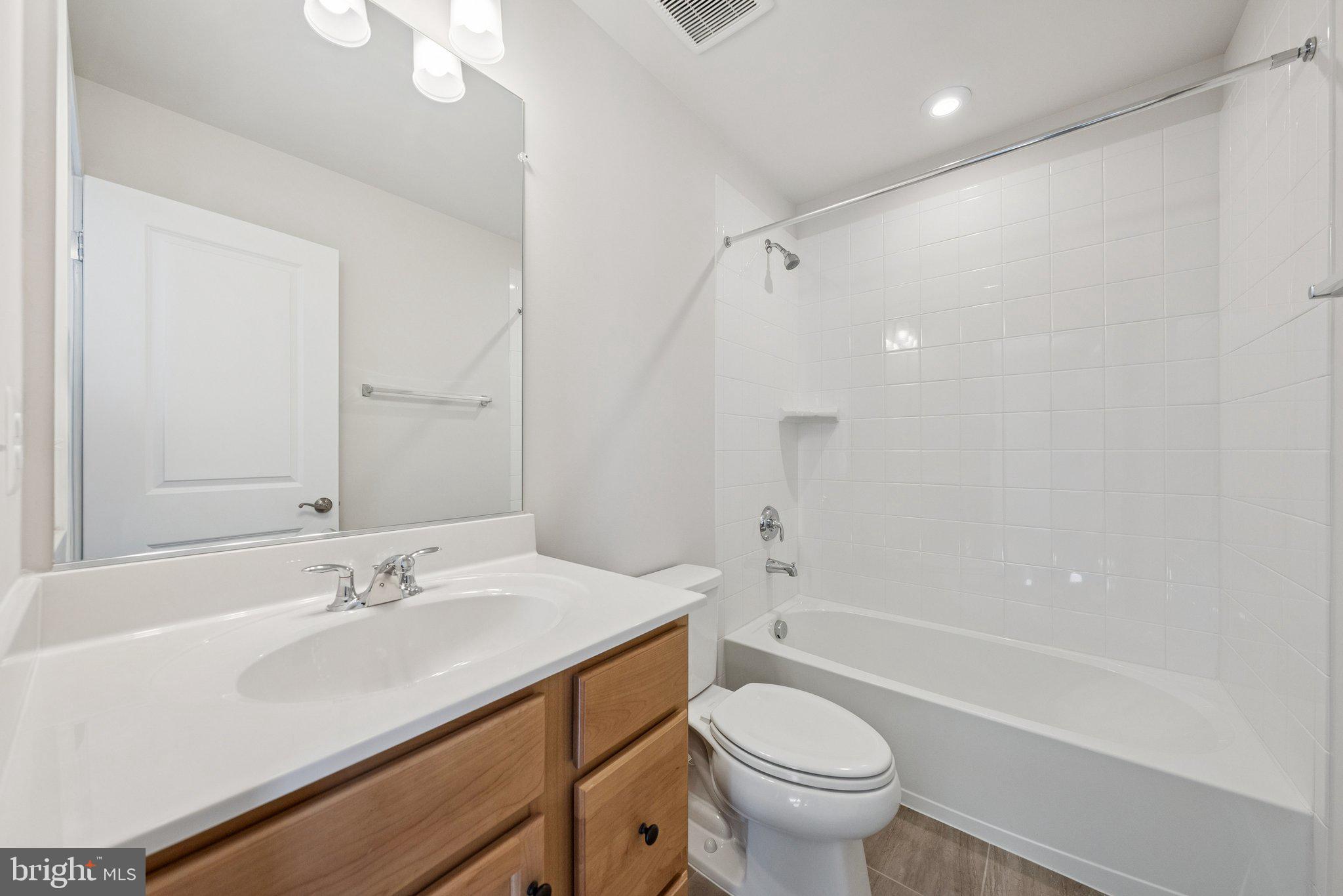 1655 Aspen Poplar Road Dumfries, VA 22026 - Photo 36 of 57 a bathroom with a sink a toilet and a large mirror
