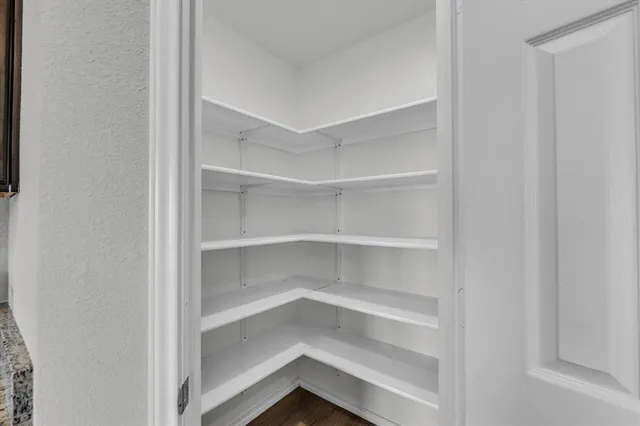 a view of walk in closet with empty racks