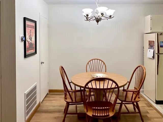 a view of a dining room with furniture a chandelier and wooden floor