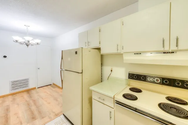 a kitchen with a refrigerator and a stove
