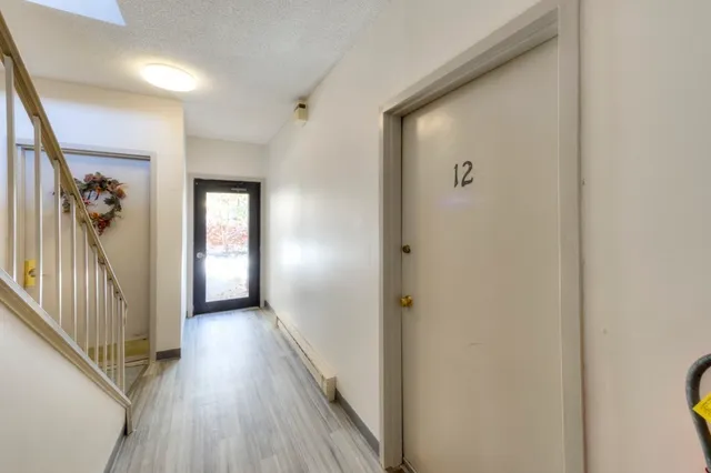 a view of a hallway with wooden floor and a living room