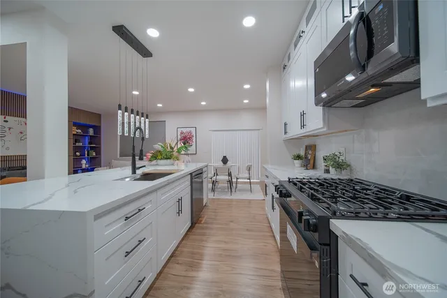 a kitchen with stainless steel appliances a sink stove and cabinets